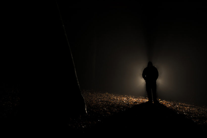 Man in forest with flashlight